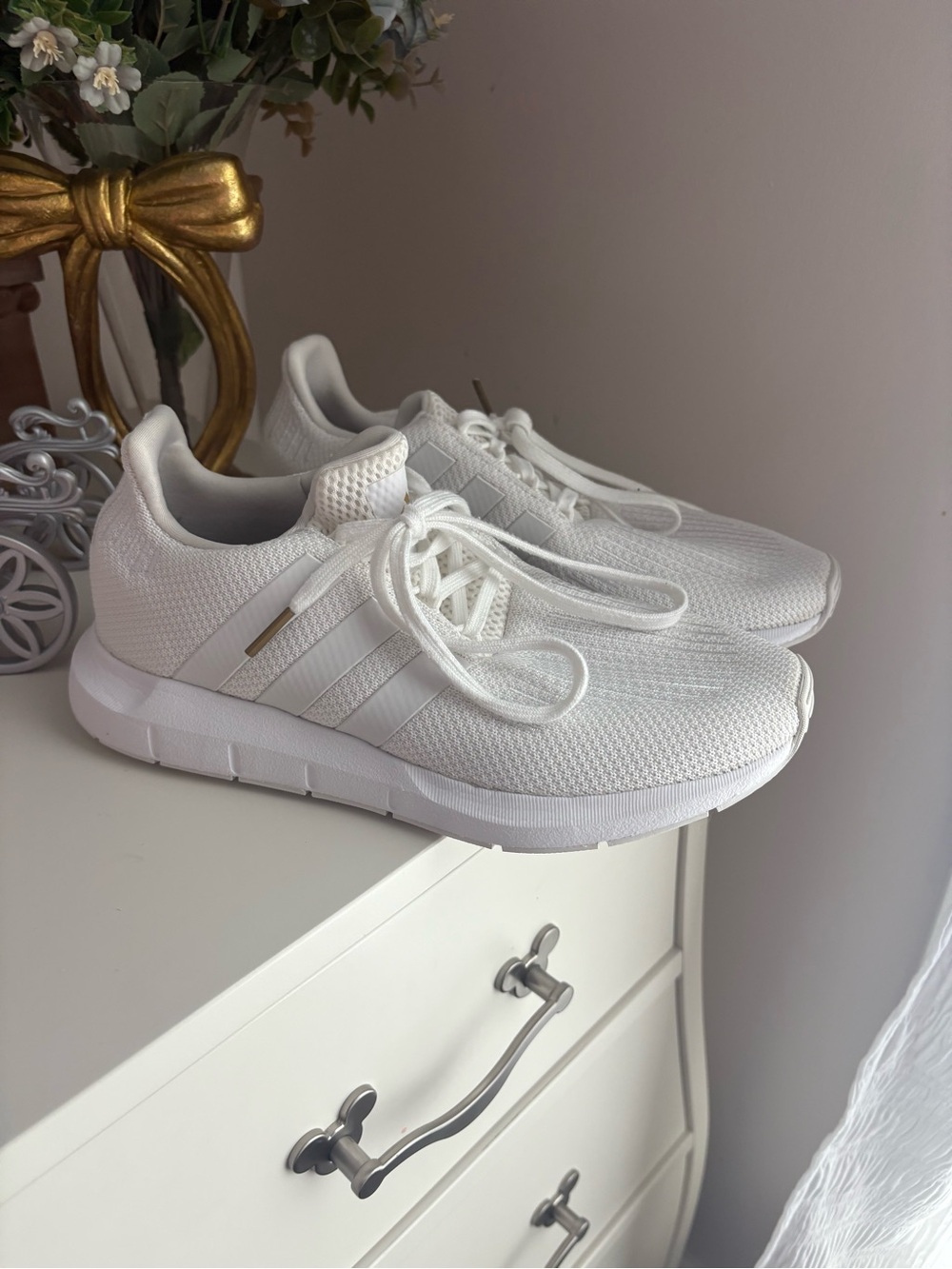 All-white Adidas Swift Run sneakers